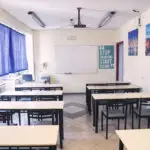 Αίθουσα διδασκαλίας των Εκπαιδευτηρίων Τάφα με θρανία, πίνακα και βιντεοπροβολέα
