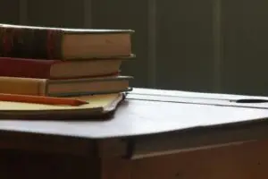 Βιβλία και μολύβι πάνω σε θρανίο, συμβολίζοντας τη γνώση και τη μάθηση